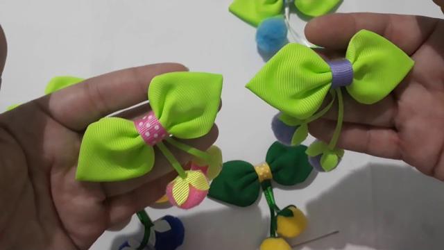 Frutinhas de pompom no laço folhinha com acabamento no bico de pato
